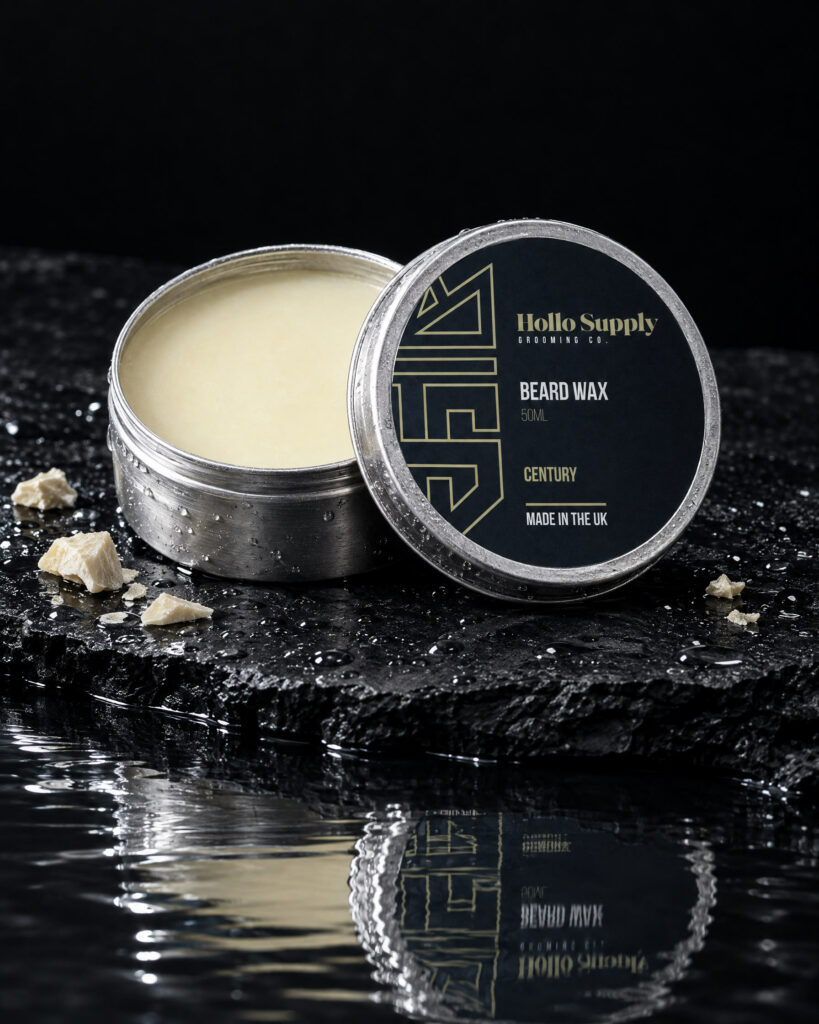 Beard Wax (Century) by Hollo Supply Grooming Co., photographed on wet charcoal stone with water