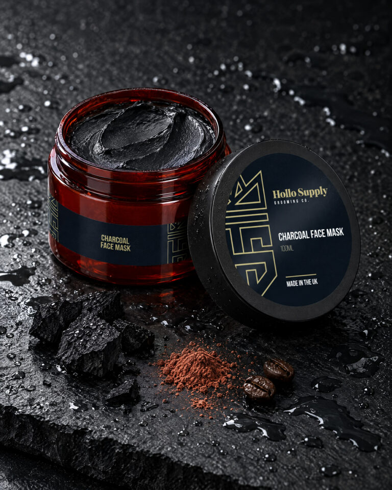Charcoal Face Mask by Hollo Supply Grooming Co., photographed on wet charcoal stone with water